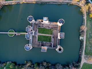 Aerial drone view of Bodiam Castle, 14th-century medieval fortress with moat and soaring towers in Robertsbridge, East Sussex, England.