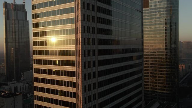 City architecture. Skyscrapers tower cityscape. Different city center buildings. Top view on downtown of big city. The sunrise when first sun rays are going through the glass windows.
