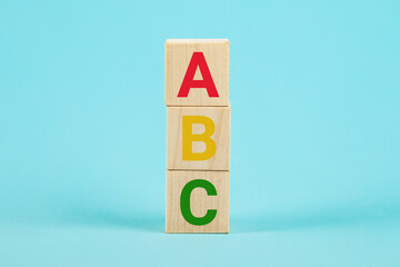 ABC on wooden blocks. ABC letters alphabet on wooden cube blocks in pillar form on blue background....