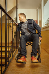 Fototapeta premium Disabled man on wheel chair riding in apartment house corridor