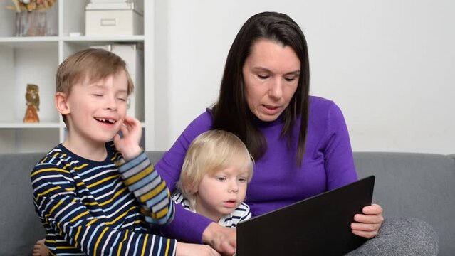 Happy kids watch learning lessons on computer together with mom