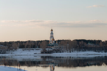 View of the Perm Epiphany Monastery across the Kama River at sunset in early spring.