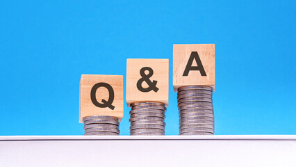 q and a - text on wood cube block stack with coins