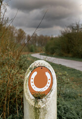Horse Trail sign next to path with dark sky