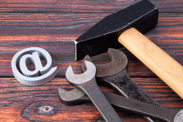 The photo shows an add icon with various tools on a wooden plate
