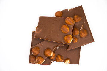 Chocolate pieces with hazelnuts on a white background