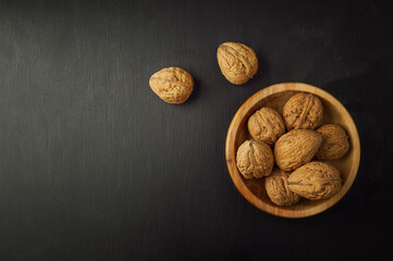 Walnut. Walnut is a healthy vegetarian protein nutritious food. Walnut kernels and whole walnuts on dark background.
