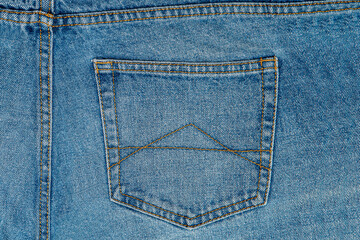 Blue jeans pocket pants or trousers made of blue-colored denim cloth. Closeup abstract background texture cotton fabric for design. Pair of jeans, rivets, buttons, seams