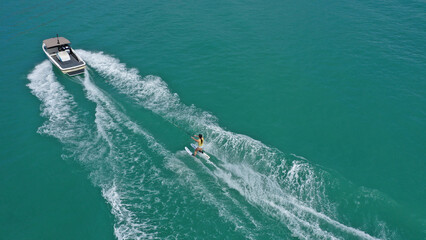 Aerial photo of extreme power boat water-sports cruising in high speed in tropical emerald bay