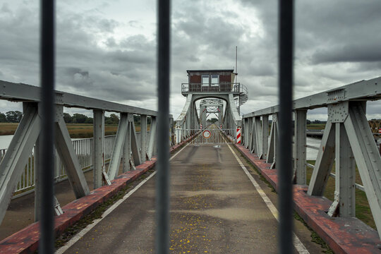Gesperrte Brücke durch ein Gitter mit dramatischem Himmel 