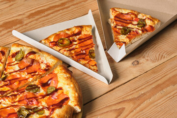 a slices of pizza in a cardboard box in the shape of a triangle for serving and take away