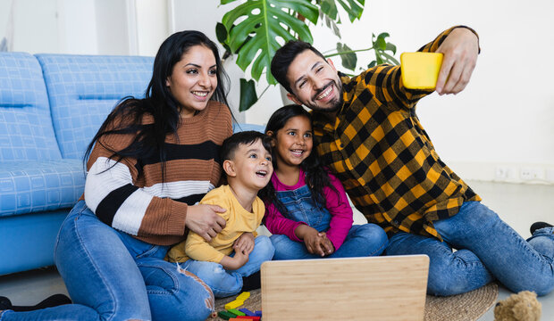 Beautiful Indian Family Father And Mother With Two Children Taking Selfie At Home