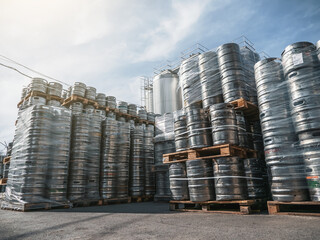 Beer kegs. Many metal barrels or containers for brewery in pallets stacked outdoors.