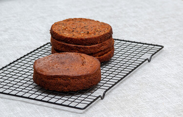 The carrot cake sponge cake is whole, and already cut into pieces on metal stand. Selective focus. Picture for articles about food, confectioners.