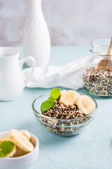 Boiled quinoa mix with banana and mint in a bowl on the table. Homemade healthy breakfast.