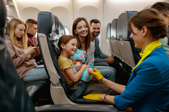 Family with child talking with stewardess in airplane