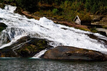 Hellesyltfossen rush down the mountain in front of a small cottage in the village Hellesylt in Møre og Romsdal fylke in Norway.