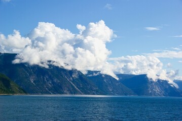 Mountains and blue sky with clouds in summer in Sognefjorden in Sogn og Fjordane fylke in Norway.
