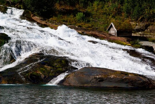 Hellesyltfossen rush down the mountain in front of a small cottage in the village Hellesylt in M&oslash;re og Romsdal fylke in Norway.