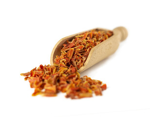  dried carrot pieces in wooden scoop isolated on white background. Spices and food ingredients. Shallow depth of field.