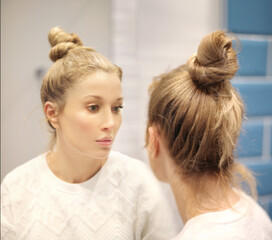 Woman looking in the mirror Applying the cream..Magic anti-aging cream.