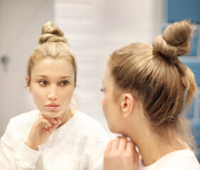 Fototapeta premium Woman looking in the mirror Applying the cream..Magic anti-aging cream.