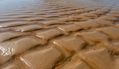 Sea Water and Sand Structure Golden fine sand on the shoreline, creating abstract pattern during the tide.