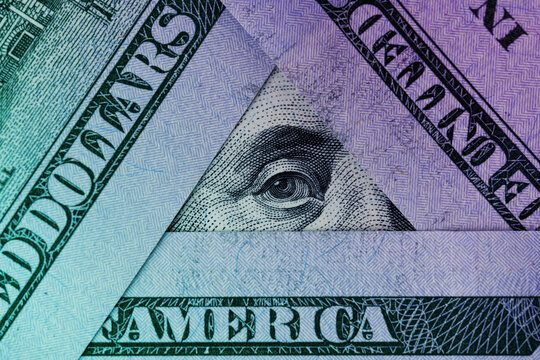 President Franklin's eye in a triangle of hundred dollar bills. Macro shot tinted in neon colors.