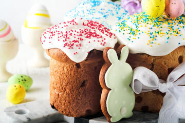 Obraz premium Traditional Easter sweet bread or cakes with white icing and sugar decor and quail eggs over white wooden table. Various Spring Easter cakes. Happy Easter day. Christian traditions. Top view.