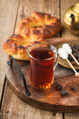 Turkish black tea. Glass cup of turkish black tea and crispy Turkish traditional bagel on old rustick background. Breakfast pastry concept. Traditional turkish brewed hot drink.