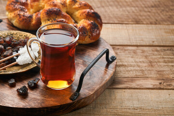 Turkish black tea. Glass cup of turkish black tea and crispy Turkish traditional bagel on old rustick background. Breakfast pastry concept. Traditional turkish brewed hot drink.