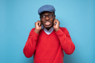 Young african man plugging ears with fingers