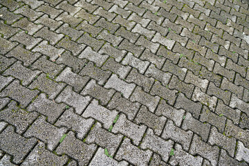 Oblique picture of stone bricks with moss and dirt lines inbetween texture pattern.
