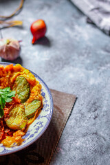 Fried Solanum melongena with Egg in a green dish on the table with garlic, dried chilli