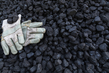 Pile of natural black hard coal for texture background. Coal energy.Coal and work gloves.