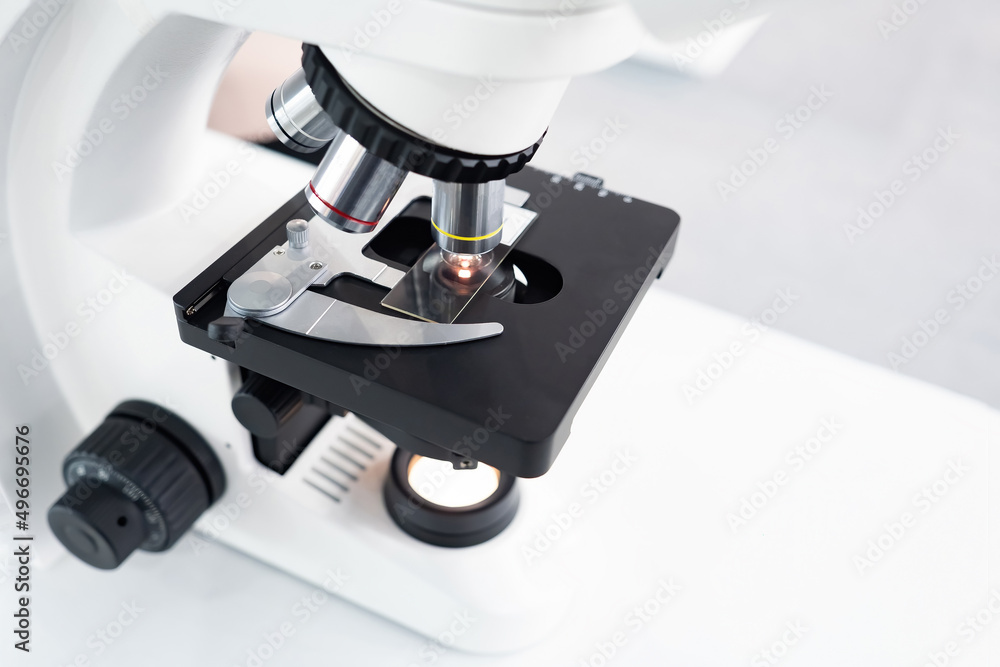 Poster fragment of a laboratory microscope close-up. platten with a sample of something inside a microscope