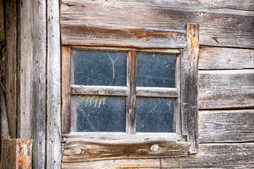 Obraz na płótnie Canvas An old small window in a wooden bath.