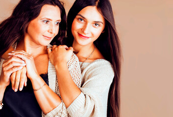 cute pretty teen daughter with mature mother hugging, fashion style brunette makeup together, warm colors