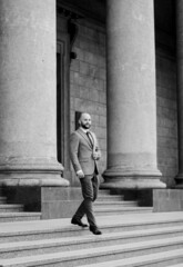 portrait of stylish young bearded man in city