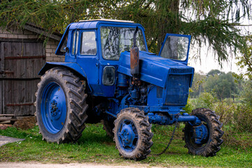 Obraz premium Old blue tractor in the countryside.