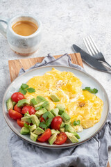 Scrambled eggs omelet with cherry tomatoes and avocado