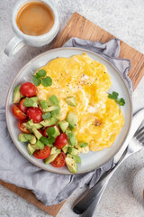 Scrambled eggs omelet with cherry tomatoes and avocado
