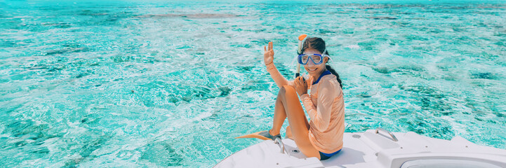 Woman going snorkeling in pefect clear water at coral reef. Happy tourist on luxury vacation...