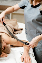 Inari massage. A girl is given an inari massage on her arm in a spa salon. Relaxing beauty treatments.