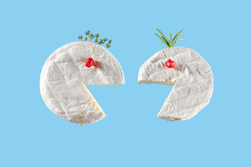 Creative food concept. Camembert or brie cheese with pomegranate, honey and thyme looks like faces
