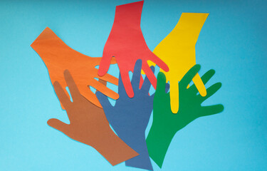 Abstract background open multicolored paper palms on a blue background.The concept of Autism Day and Youth Solidarity Day