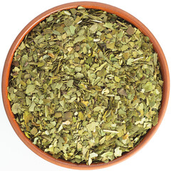 Mate tea leaf (Ilex paraguariensis) in a brown ceramic bowl isolated on white background. Isolated...