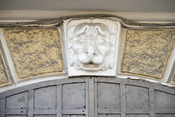 Plaster lion's head on the wall of the building. Historical modeling in the form of a head on the building of the house. Ancient architecture.