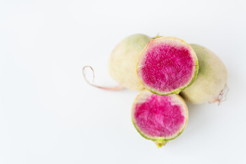 Delicious pink radish in the cut of the dragon's eye variety on a white background.