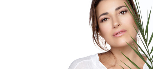 Natural beauty with a tropical leaf. Beautiful woman with a healthy hydrated and glowing skin....
